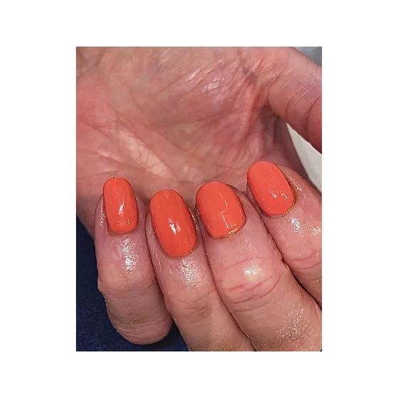 A glossy coral gel manicure by Luxxe Beauty